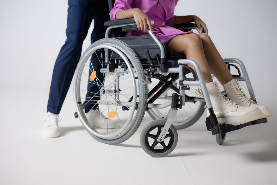 Acessibilidade Brasil — Woman in a pink outfit sitting in a wheelchair, highlighting inclusive fashion.