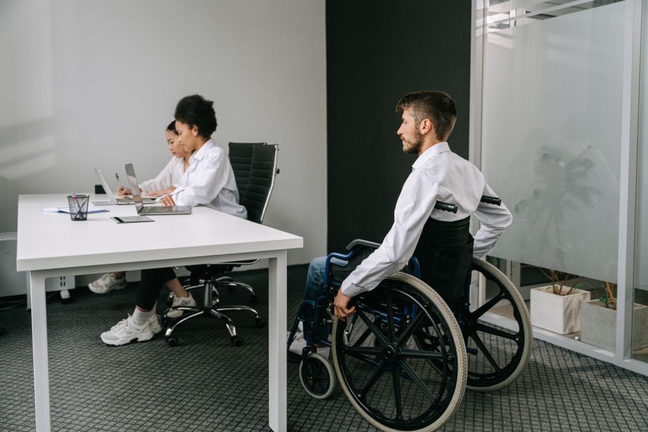 Acessibilidade Brasil — Diverse team in an office meeting, focusing on inclusive workplace and accessibility.