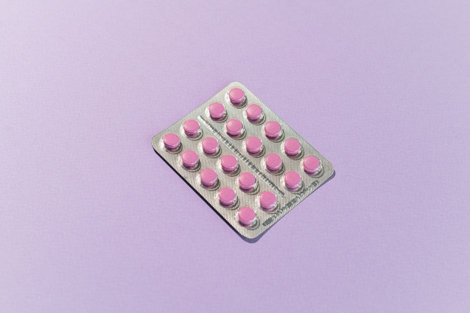 Acessibilidade Brasil — Blister pack containing pink tablets on a lavender background, highlighting healthcare theme.