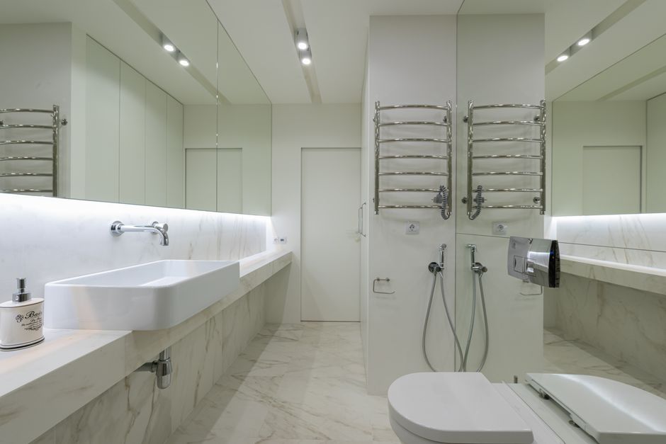 Acessibilidade Brasil — Interior design of modern restroom with toilet under mirror with sink and faucet on opposite wall