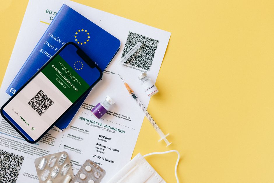 Acessibilidade Brasil — Digital vaccine passport and COVID-19 vaccination items including syringes and masks on a yellow