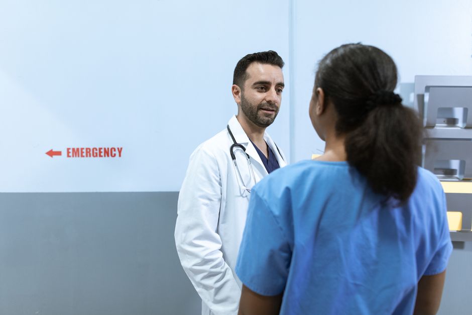 Acessibilidade Brasil — Doctors and nurses conversing near emergency room in a hospital setting.